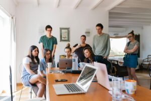 Groupe de jeunes professionnels engagés dans une réunion collaborative dans un environnement de bureau moderne.