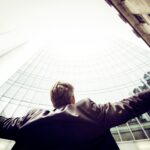 photographie en contre-plongée d'un homme au milieu de bâtiments