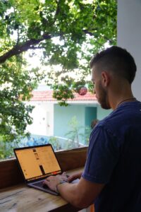 homme en chemise bleue à col rond assis sur un banc en bois marron pendant la journée