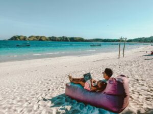 un homme assis sur un pouf sur la plage