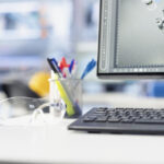 Close up of computer on desk displaying live metrics in renewable energy facility, tracking solar panel assembly progress. Stationary items on photovoltaics factory engineering workspace desk