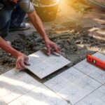 Pose méticuleuse de carreaux à motifs par un bon carreleur à Belley sur un lit de mortier frais