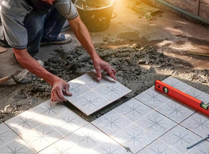 Pose méticuleuse de carreaux à motifs par un bon carreleur à Belley sur un lit de mortier frais